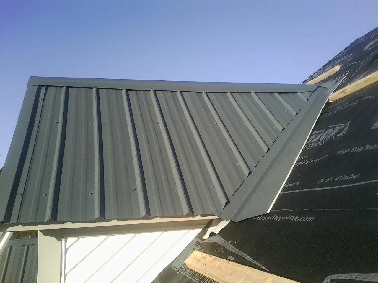 Gray metal roof panels going on over a garage gable in Clayville