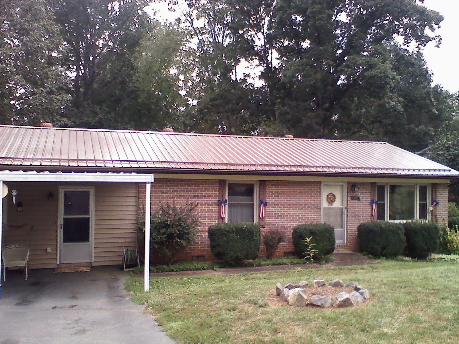 Bronze metal roof and carport on a brick ranch home — Roof Repair work by our crew in Clayville
